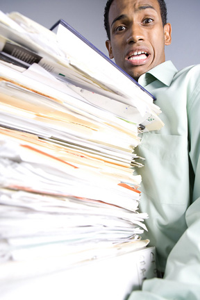 A frightened man carrying a stack of folders.